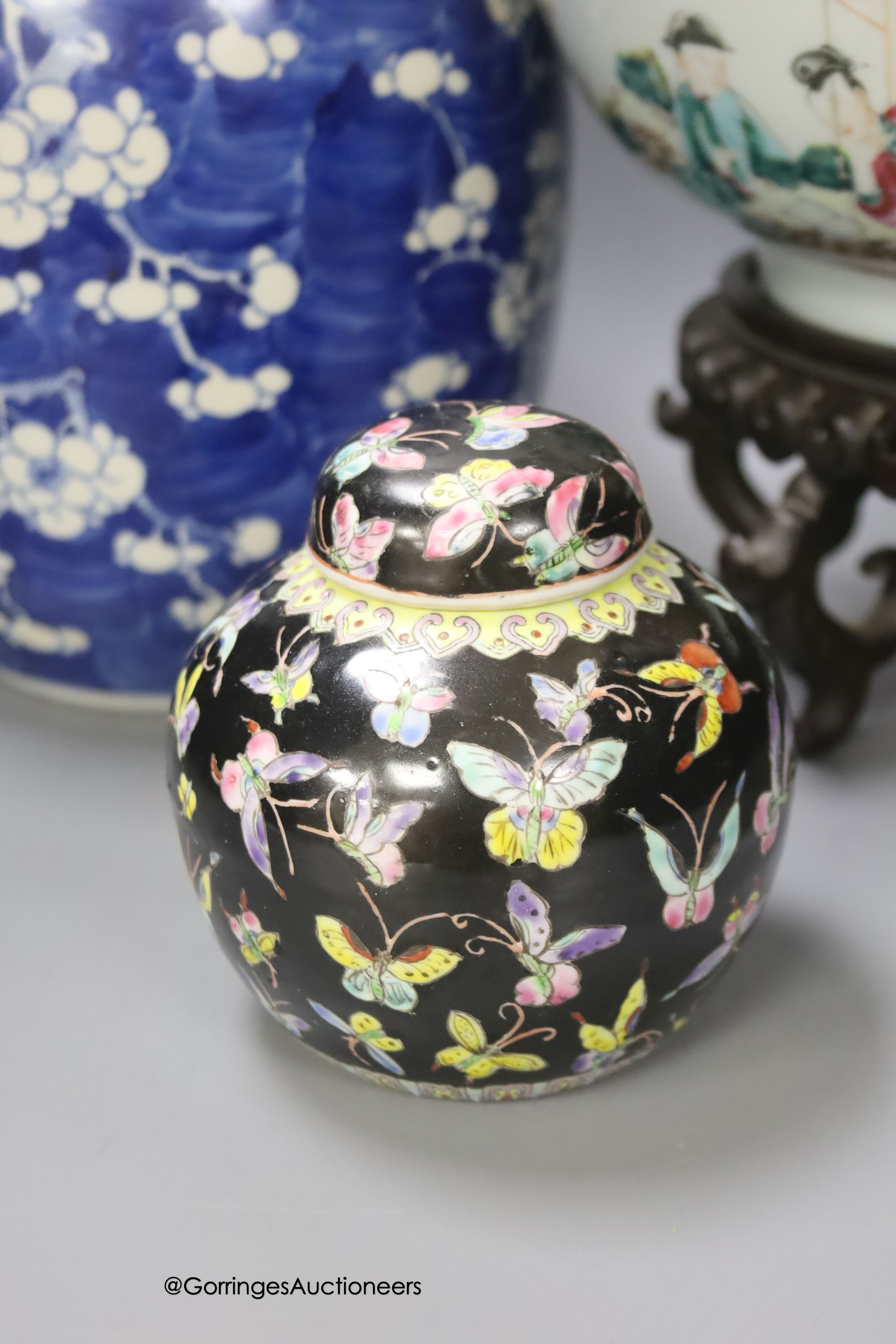 A 19th century Chinese porcelain prunus jar and cover, 27cm, on carved wood stand, a smaller famille noire jar and cover, a Chinese export fruit bowl, blue and white dish and a similar jar and cover 27cm